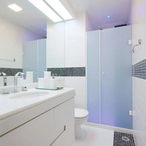 Box de vidro de abrir instalado em banheiro branco compacto